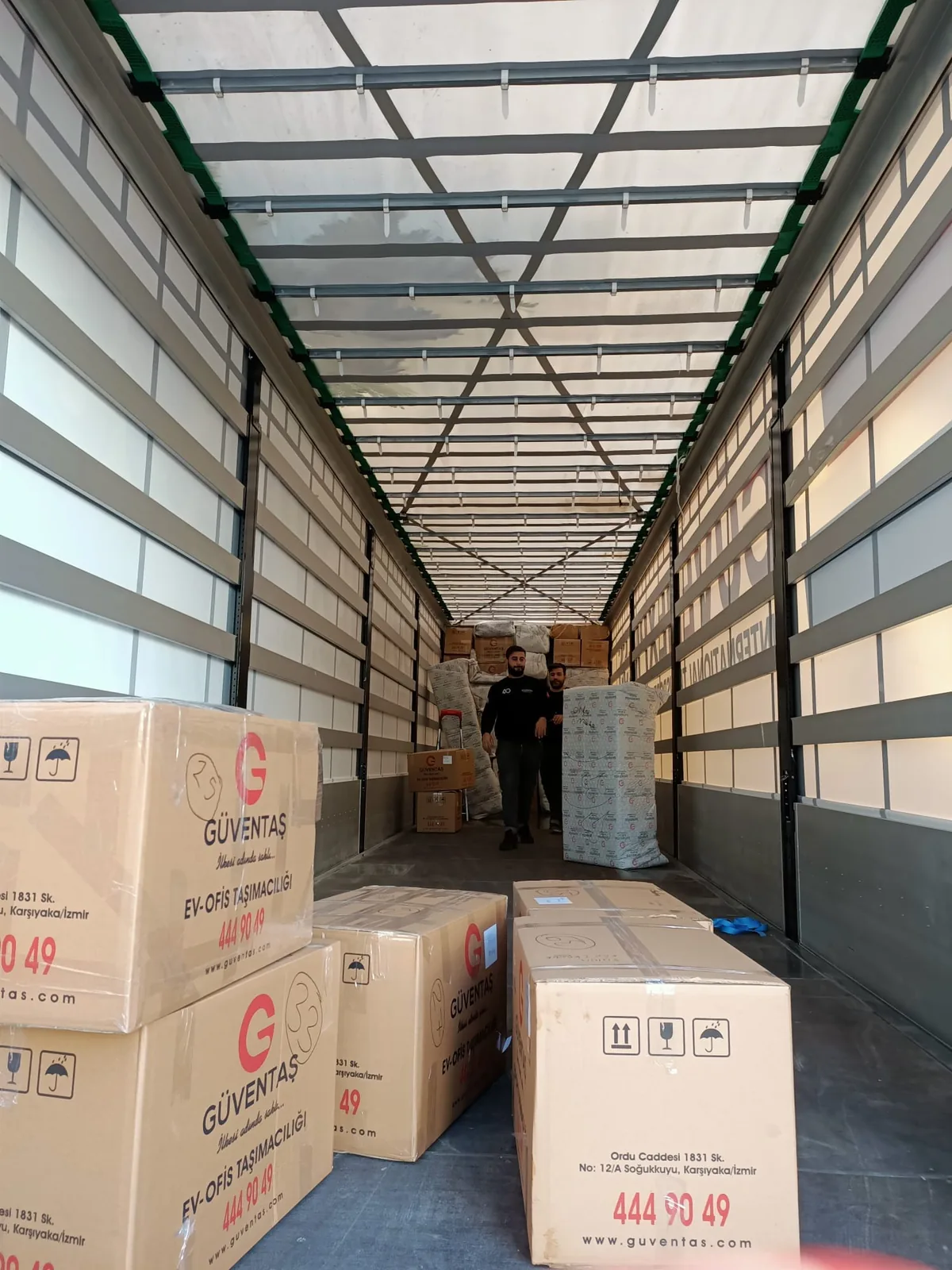 Branded GüvenExpress parcels arranged inside a freight trailer